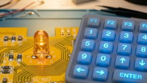 A backlit silicone keypad with a LED bulb and a yellow circuit board