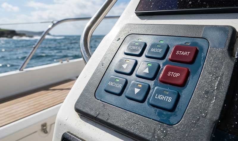 UV resistant silicone rubber keypad integrated into a boat console panel seen with the ocean and coastline blurred in the background