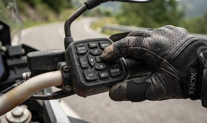 gloved hand operating a multi button Motorbike Silicone Keypad mounted on the motorcycle handlebar