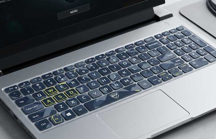 A gaming laptop featuring a custom dark styled Silicone Laptop Keyboard Cover with highlighted WASD keys rest on a clean desktop